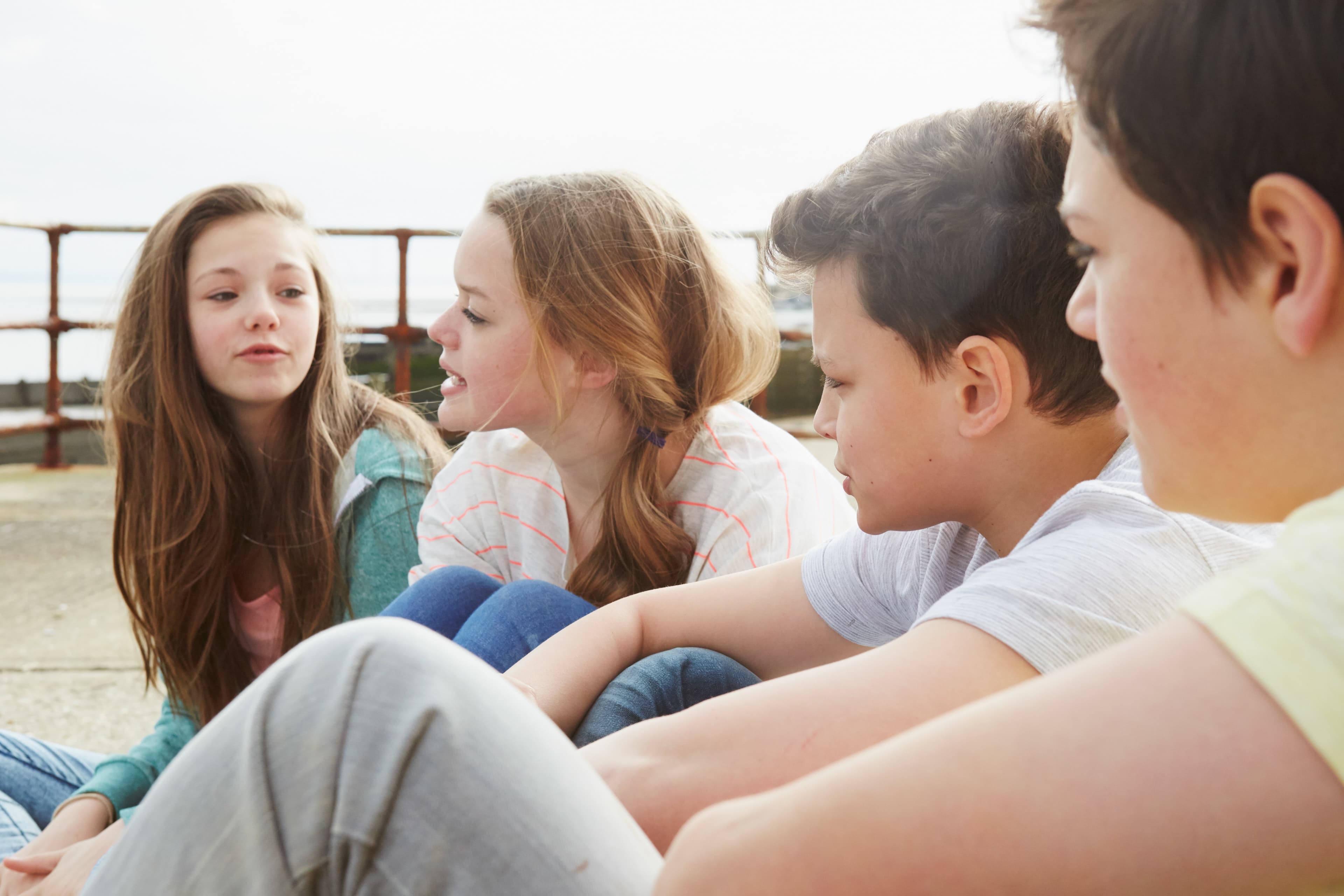 Pre-teens sitting outside chatting during the middle-school years
